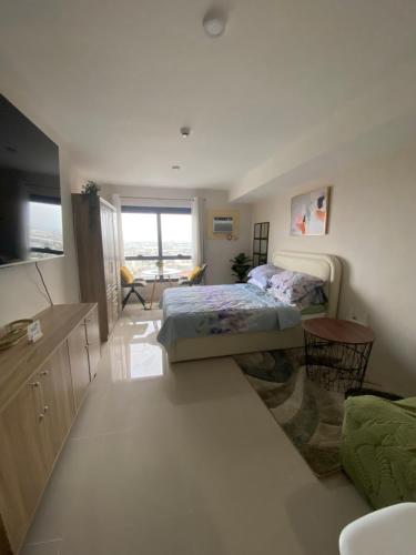 a bedroom with a bed and a television in a room at Jbs place at Jtower Residences in Mandaue City