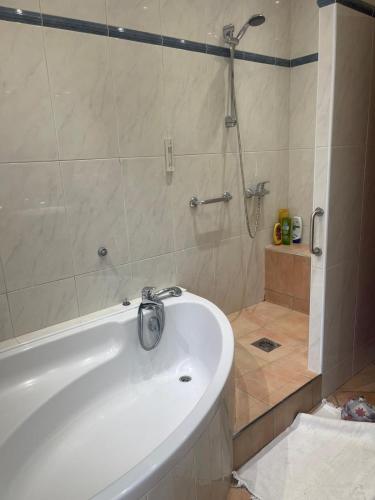 a bathroom with a white tub and a shower at Violette in Bazus
