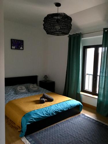 a bedroom with a bed in a room with green curtains at Violette in Bazus