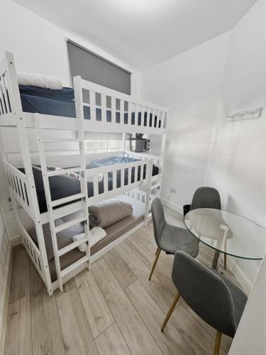 a room with a bunk bed and a table and chairs at Trio Den in Zone 2 - Willesden Green in London