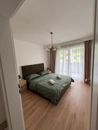 a bedroom with a bed and a large window at Apartament Eroilor Residence in Floreşti