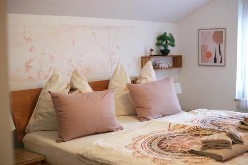 a bed with a bunch of pillows on it at Baum Apartments in Bad Tatzmannsdorf