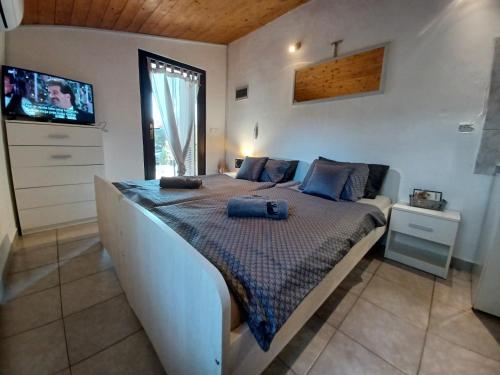 ein Schlafzimmer mit einem Bett mit blauen Kissen in der Unterkunft Pampas studio, self check-in, private parking in Poreč