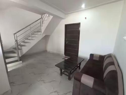 a living room with a couch and a table and stairs at 3bhk Villa WIth Terrace in Alwar