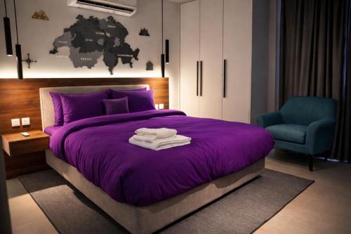 a bedroom with a purple bed and a blue chair at Serene Comfort Suites in Rawalpindi