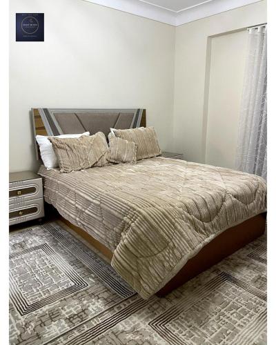 a bedroom with a large bed with a bed frame at Half Moon Apartaments in Alexandria