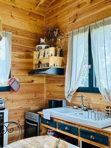 a kitchen with a large white sink in a wooden wall at cab Anne in Léon
