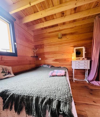 a bedroom with a bed in a wooden cabin at cab Anne in Léon