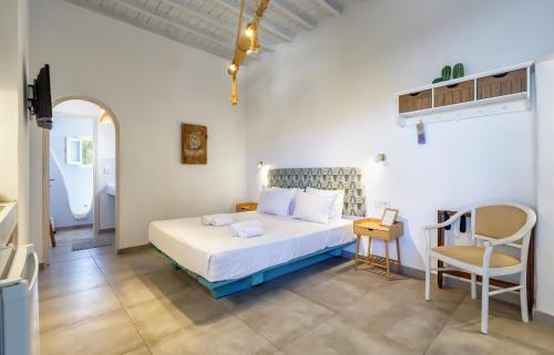 a bedroom with a bed and a table and a chair at Bella Alba in Kalafatis