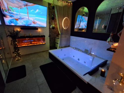 a large bathroom with a tub and a tv at la chambre d'hôte de glad et guigui in Rinxent