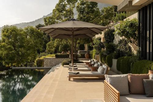 a patio with chairs and an umbrella next to a pool at Rose Bank in Johannesburg