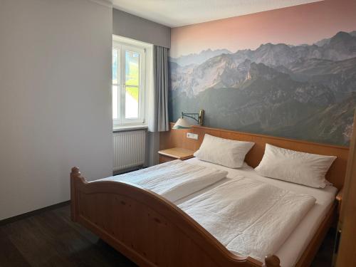 a bedroom with a bed with a large painting on the wall at Gasthof Rössle in Sulzberg