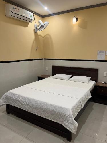 a bedroom with a bed and a air conditioner on the wall at Khách Sạn 68 Trần Đề in Ấp Nhà Việc