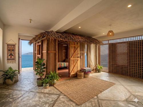 a room with a room with a bed and the ocean at Villalola in Nosy Be