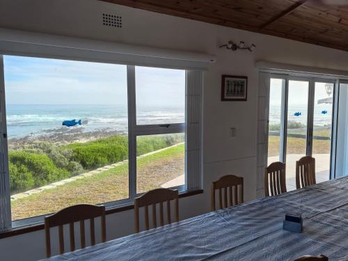 a dining room with a table and a view of the ocean at The Lookout in Pearly Beach