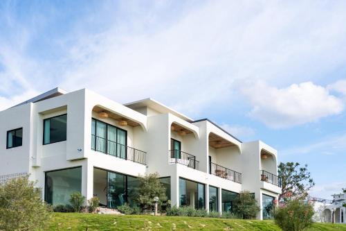 a white building with windows on a hill at The Peak Hill Pool Villa in Ban Wa Kachieo