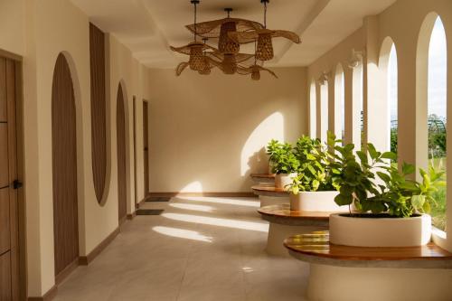 a hallway with potted plants and a chandelier at The Peak Hill Pool Villa in Ban Wa Kachieo