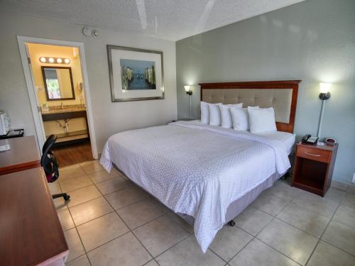 a bedroom with a large bed with white sheets and pillows at Clearwater Beach Hotel in Clearwater Beach