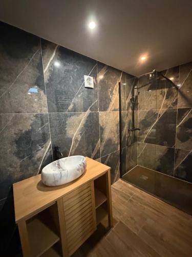 a bathroom with a shower with a bowl on a table at Appartement et spa in Douai