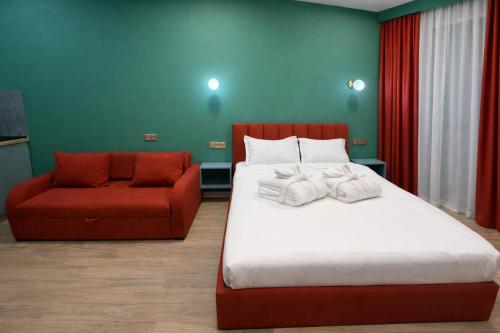 a bedroom with a bed and a red chair at Premium New Gudauri Apartments with Balcony & Gondola Views in Gudauri