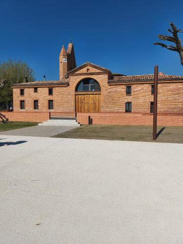 a brick building with a wooden gate in front of it at Canal du midi in Bazus