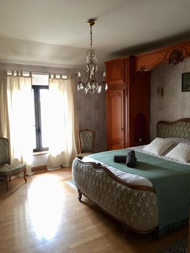 a bedroom with a large bed and a chandelier at Canal du midi in Bazus