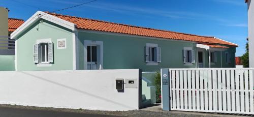 a small blue house with a white fence at Casa da Avó Biza in São Roque do Pico