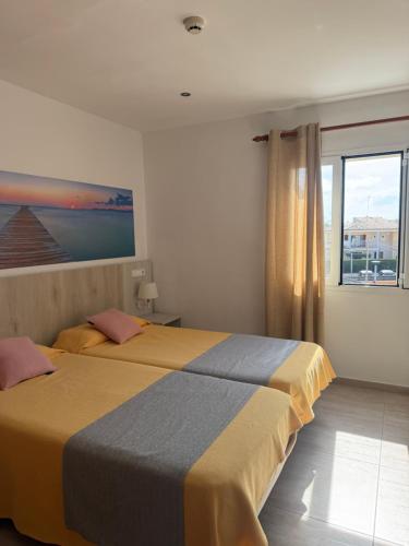 a bedroom with two beds and a window at Venecia Apartments in Port d'Alcudia