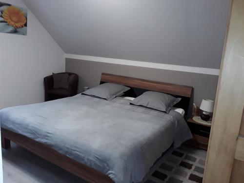 a bedroom with a bed and a chair at Chambres d'Hôtes Arnold in Dambach-la-Ville
