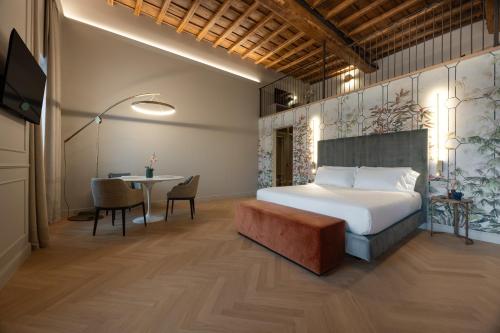 a bedroom with a bed and a dining table at Villa Clementi Boutique Hotel in Cave