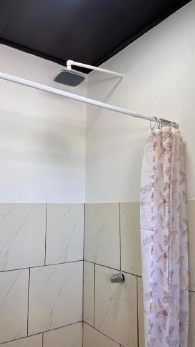 a shower curtain is hanging in a bathroom at Matapalo Hosting in Savegre