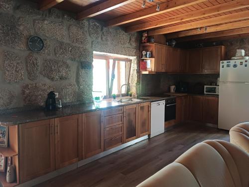 a kitchen with wooden cabinets and a white refrigerator at Casa da Fragoeira in Gandarela