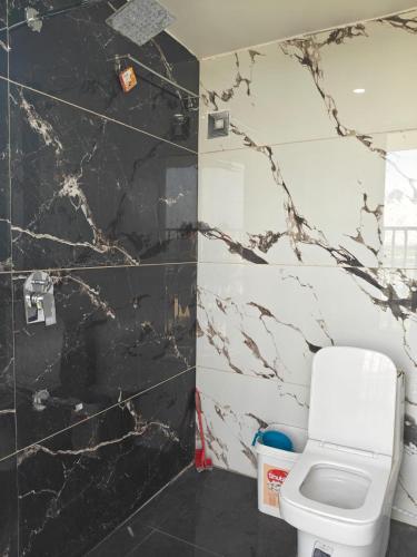 ein Badezimmer mit einer schwarz-weißen Marmorwand in der Unterkunft Hotel Aero View in Dabok