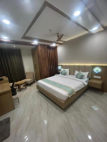 a bedroom with a large bed and a desk at Hotel Vardaan Inn in Lucknow