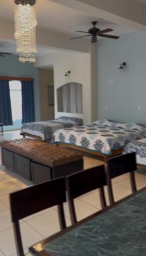 a bedroom with two beds and a table in it at Mega Suite en Hotel Cosmos in Tamasopo