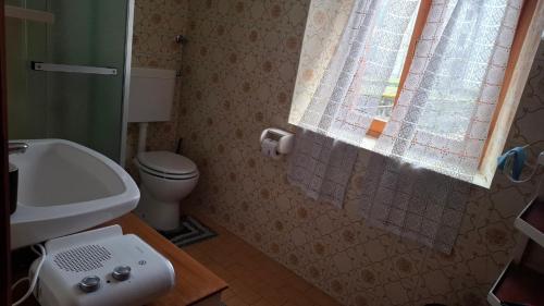 a bathroom with a sink and a toilet and a window at La Dimora di Beatrice in Santa Brigida
