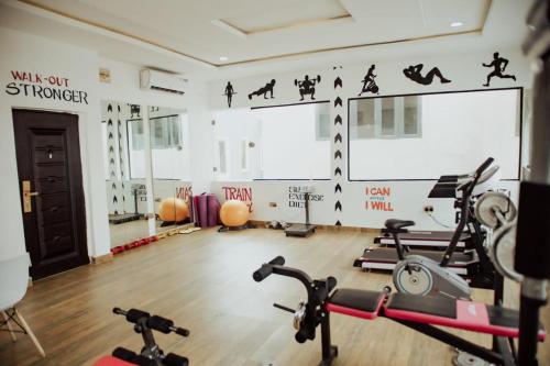 a gym with two treadmills and two exercise bikes at Olive apartment in Maiyegun