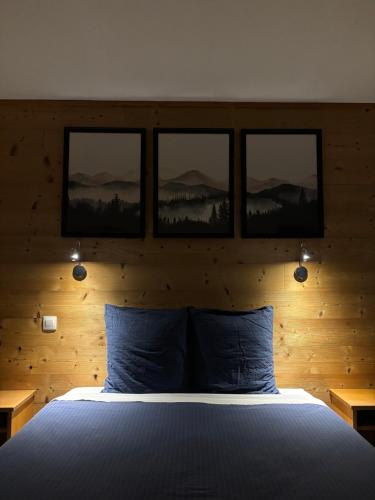 a bedroom with a bed with four pictures on the wall at Les Hauts du Lac in Gérardmer