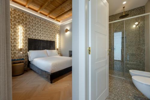 a bedroom with a bed and a shower and a sink at Villa Clementi Boutique Hotel in Cave