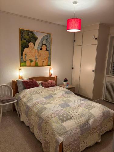 a bedroom with a bed and a painting on the wall at Apartment 2 min from airport 10 min to city in Copenhagen