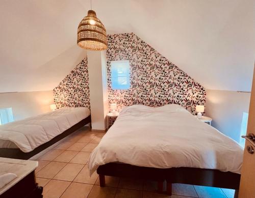 a bedroom with two beds and a wall mural at Gîte La Clef des Champs in Libin