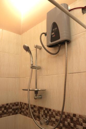 a shower in a bathroom with a blow dryer at Lechugal Guest House in Cusco