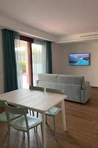 a living room with a couch and a table and chairs at AQUAGARDEN Short Lets in Polignano a Mare