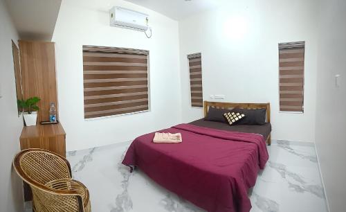 a bedroom with a bed with a purple blanket at Sandora Home Stay in Varkala