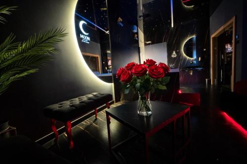 a vase of roses on a table in a room at Moon Luxury Apartment - Jacuzzi & Sauna in Wałbrzych