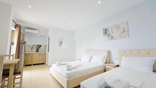 a hotel room with two beds and a table at ARILEO ROOMs in Himare