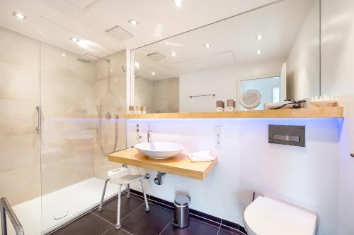 a bathroom with a sink and a shower at Ferienwohnung Morgensonne - modern und freundlich in zentraler Lage in Langenargen