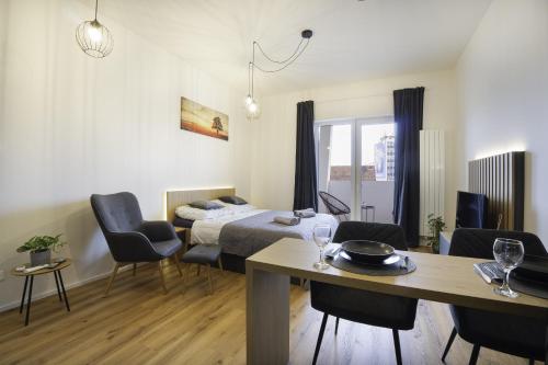 a room with a bed and a table and chairs at Calmora apartment Optická WiFi Klimatizace Balkon Nespresso in Komárov