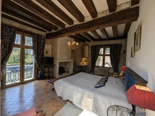 a bedroom with a large bed and a fireplace at Manoir de la Maison Blanche in Amboise