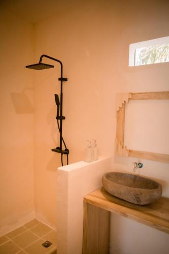 a bathroom with a stone sink on a counter at Daumi House in Masbagik